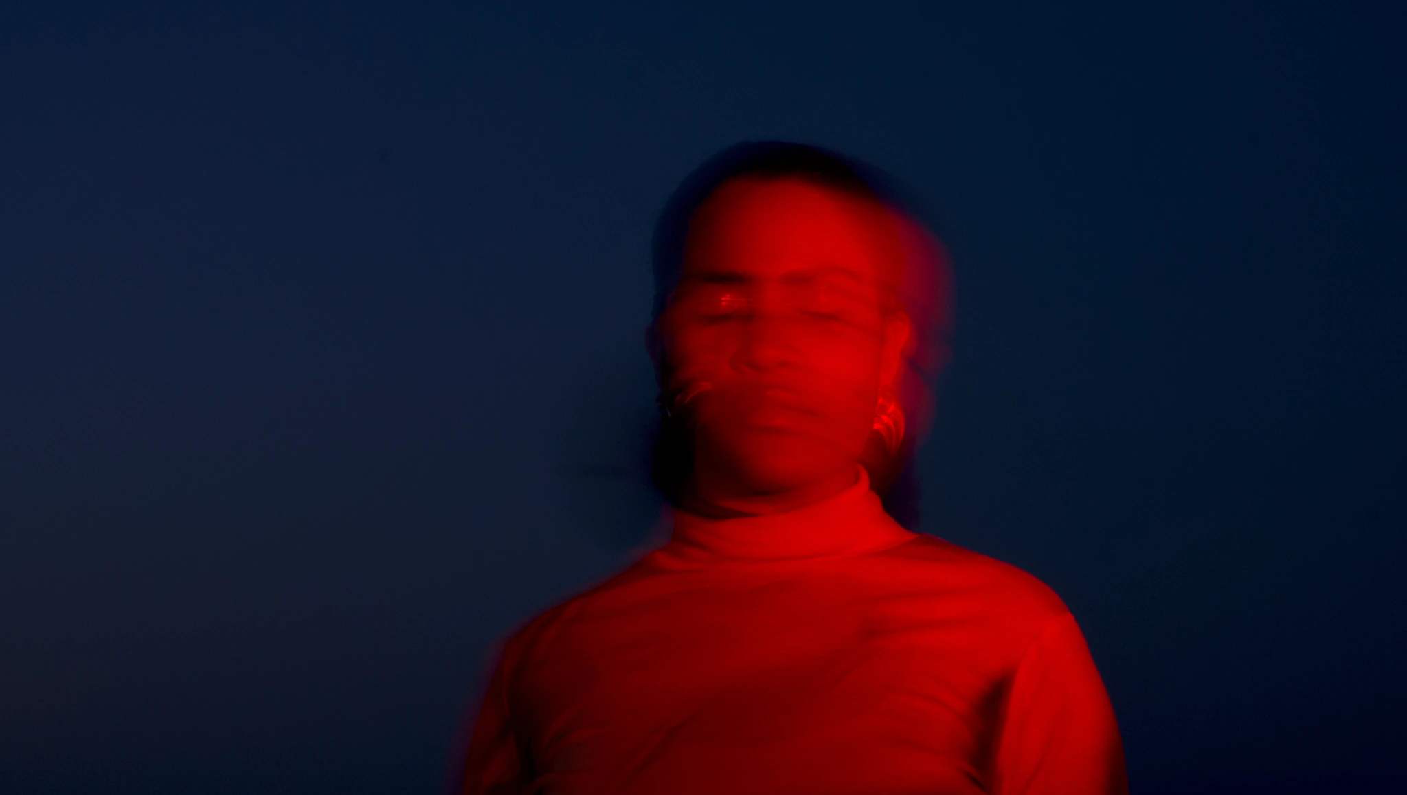 Anna Bassy: ritratto mosso in luce rossa su fondo blu