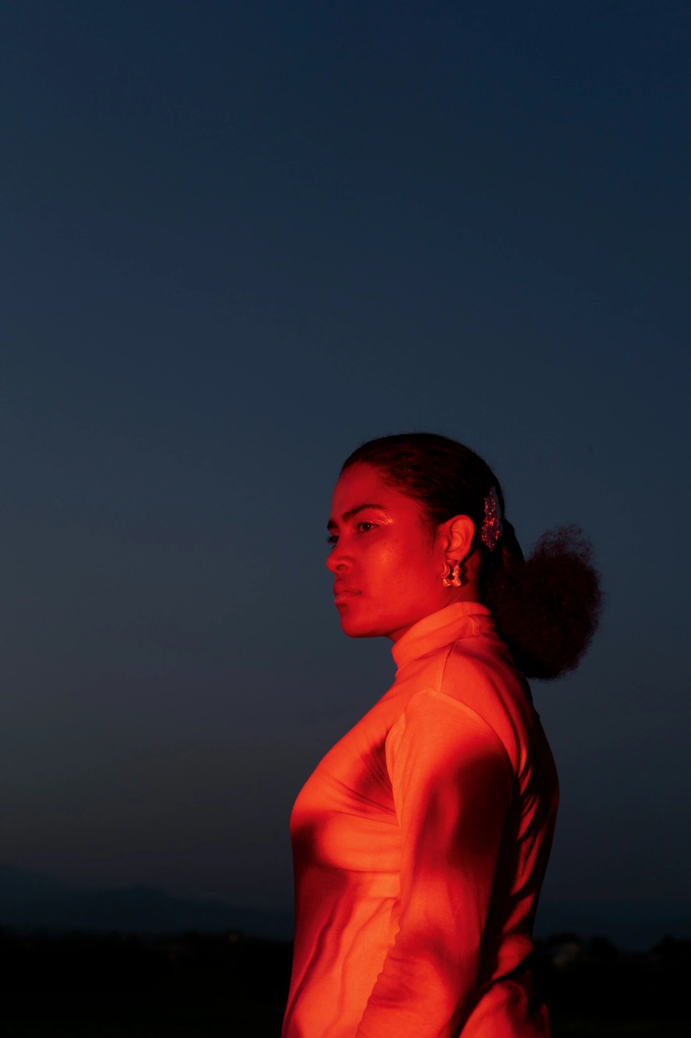 Anna Bassy di profilo in luce rossa su fondo blu